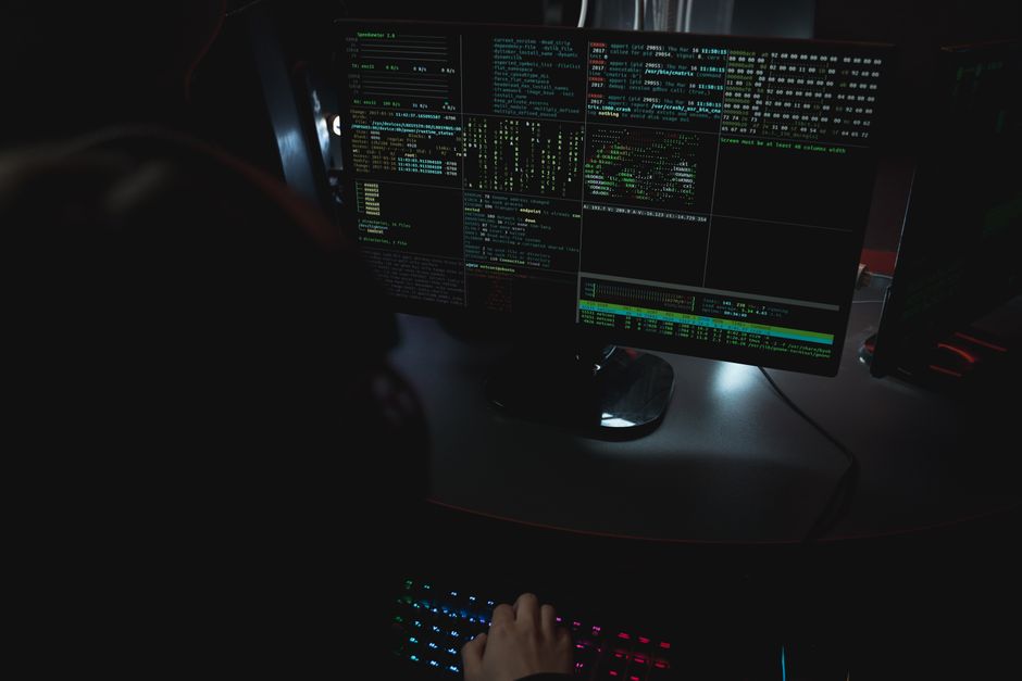 Dark room setup with code displayed on PC monitors, representing a Codex CLI session