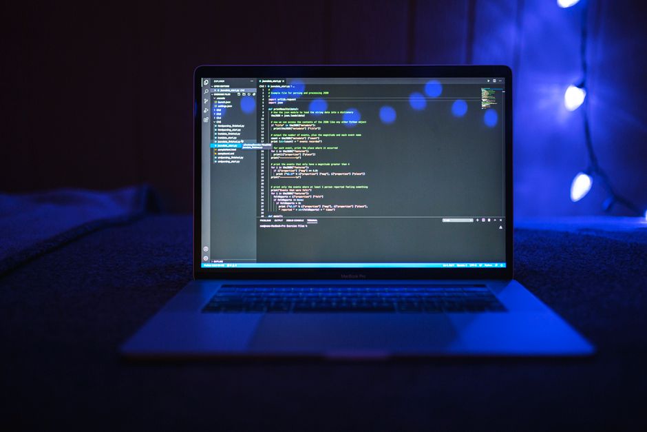 Laptop screen showing code in blue light, representing reducing token usage in Cursor